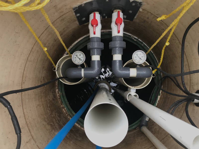 sewer pumps inside basin with pipes and gauges